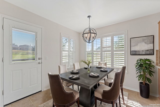 dining room featuring a healthy amount of sunlight, an inviting chandelier, light tile patterned floors, and baseboards