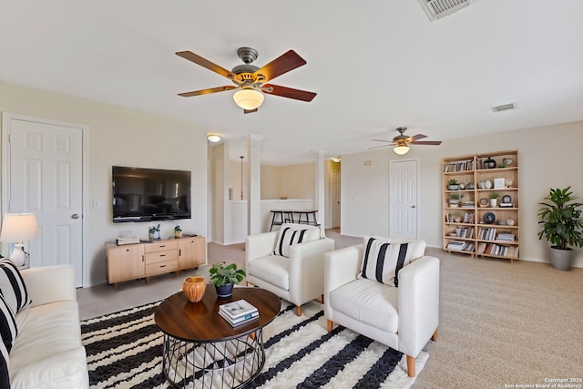 carpeted living area featuring decorative columns, visible vents, and a ceiling fan