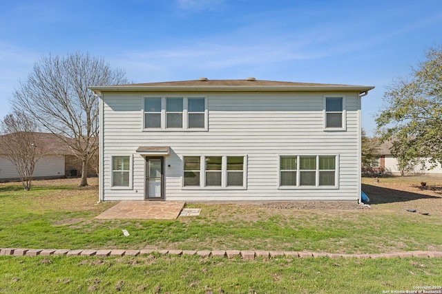 rear view of house featuring a yard and a patio