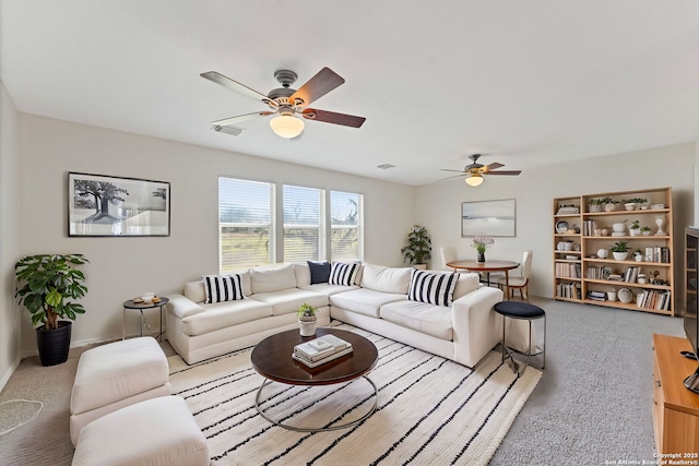 living room featuring a ceiling fan, baseboards, visible vents, and carpet flooring