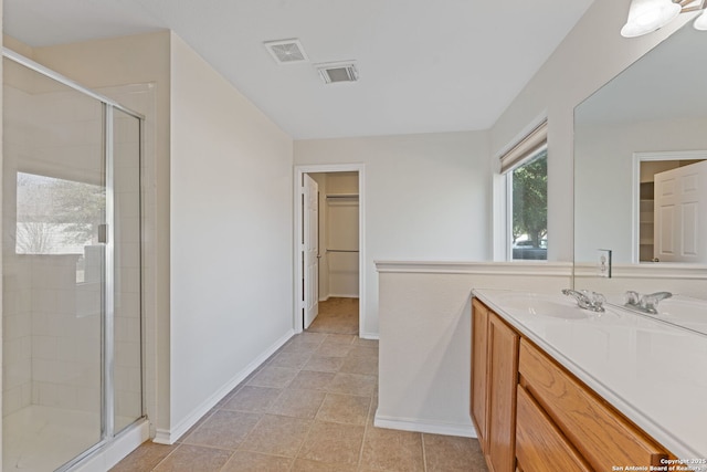 bathroom featuring vanity, a shower stall, visible vents, and baseboards