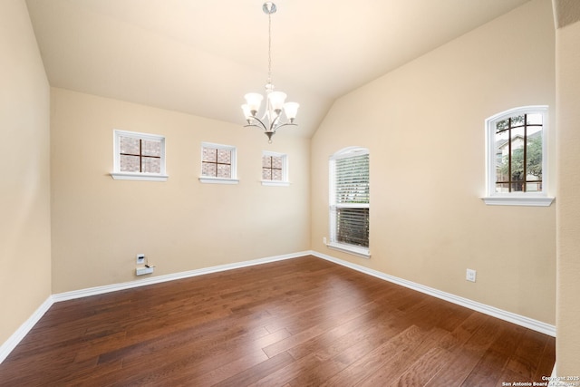 unfurnished room with vaulted ceiling, dark wood-type flooring, baseboards, and a notable chandelier