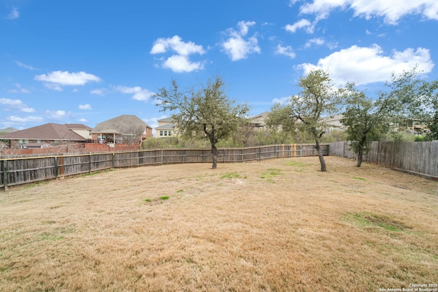 view of yard with a fenced backyard and a residential view