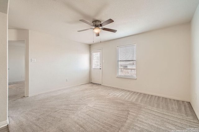 spare room featuring carpet flooring, ceiling fan, a textured ceiling, and baseboards