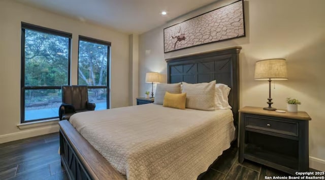 bedroom with dark wood-type flooring, multiple windows, and baseboards