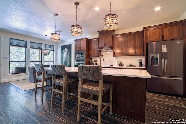 kitchen with a sink, backsplash, stainless steel appliances, and light countertops