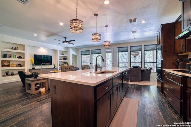 kitchen featuring light countertops, a sink, and dark wood finished floors