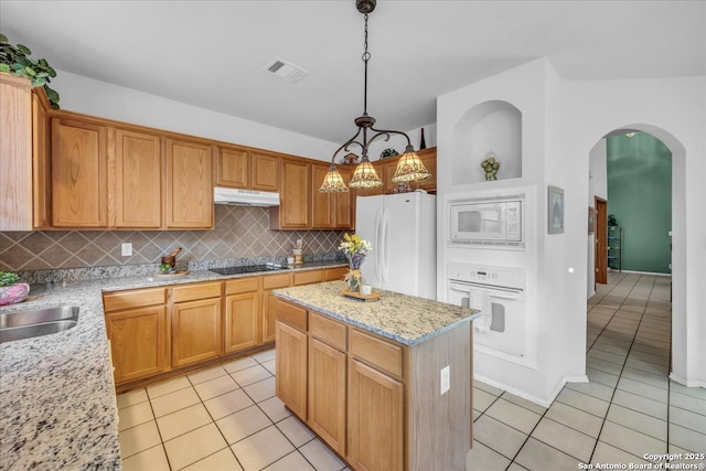 kitchen featuring white appliances, visible vents, under cabinet range hood, and light tile patterned floors