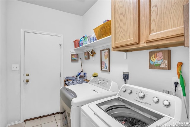 laundry room with cabinet space, light tile patterned floors, and washer and clothes dryer