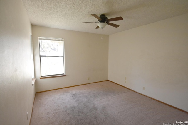 empty room with a textured ceiling, carpet floors, a ceiling fan, and baseboards