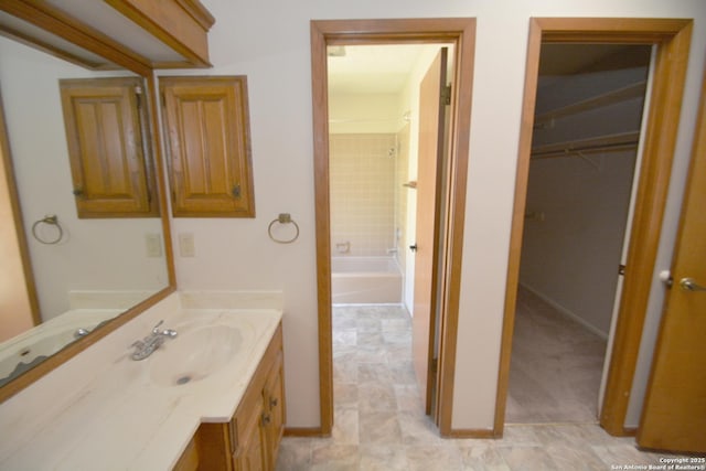 bathroom featuring vanity, baseboards, and shower / bathtub combination