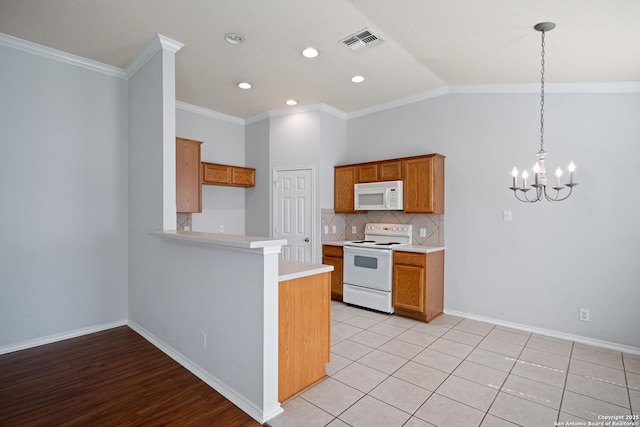 kitchen with white appliances, tasteful backsplash, visible vents, brown cabinets, and light countertops