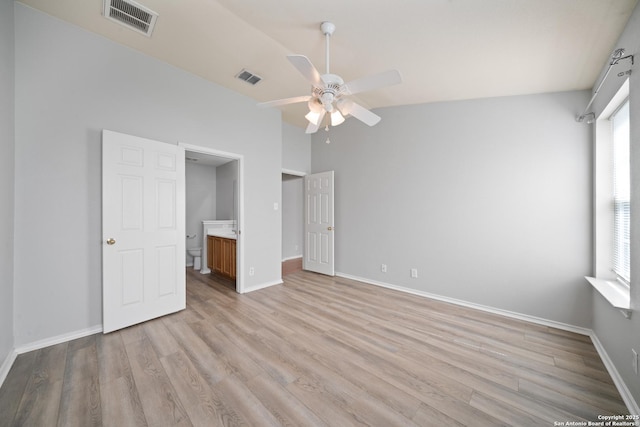 unfurnished bedroom featuring lofted ceiling, baseboards, visible vents, and light wood finished floors