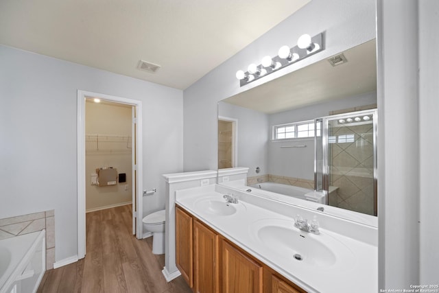 bathroom with a garden tub, visible vents, and a sink