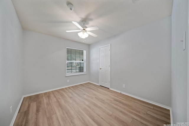 unfurnished room with ceiling fan, light wood-type flooring, and baseboards