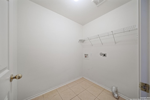 clothes washing area featuring washer hookup, visible vents, electric dryer hookup, laundry area, and baseboards