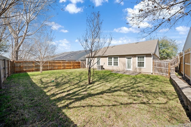 rear view of property with a fenced backyard and a lawn