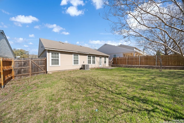 back of property featuring a fenced backyard, central AC unit, and a lawn