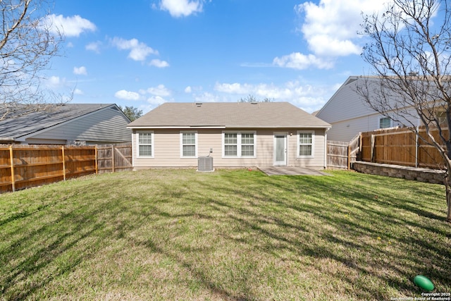 rear view of house with a patio area, a fenced backyard, central AC unit, and a yard