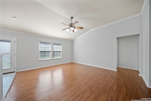 spare room featuring ceiling fan, lofted ceiling, crown molding, and wood finished floors