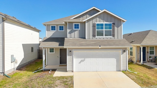 view of front of home with driveway, an attached garage, a front lawn, and board and batten siding