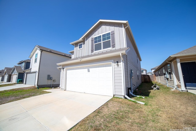 view of front of property with an attached garage, concrete driveway, board and batten siding, and a front yard