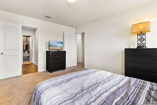 bedroom featuring light carpet, visible vents, and baseboards