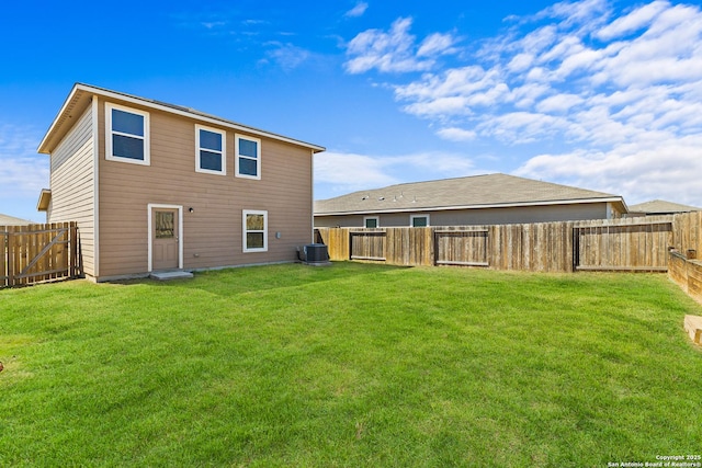 rear view of house with a fenced backyard, central AC unit, and a yard