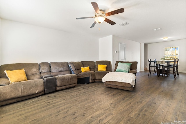 living room with dark wood-style flooring, visible vents, and ceiling fan