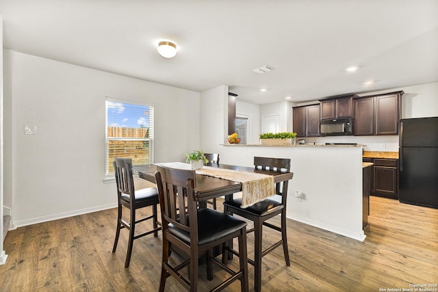 dining space with recessed lighting, wood finished floors, visible vents, and baseboards