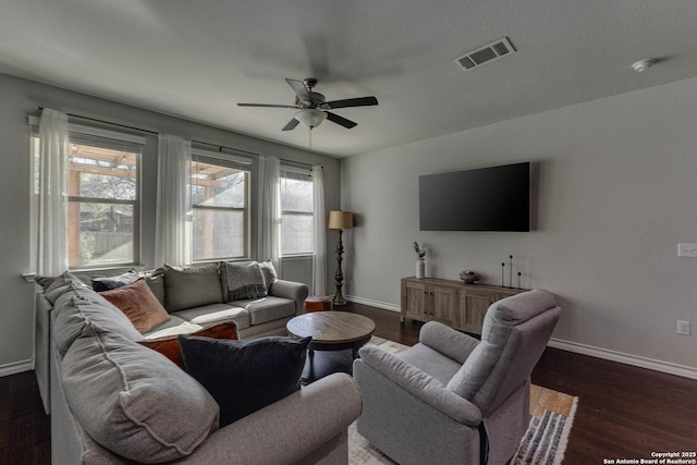 living area featuring a ceiling fan, baseboards, visible vents, and wood finished floors