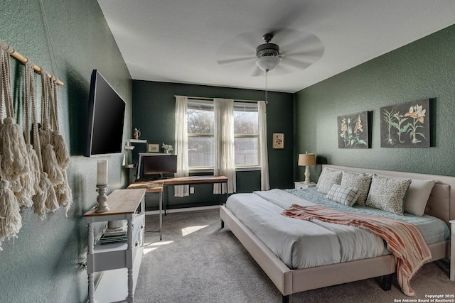 carpeted bedroom featuring ceiling fan and a textured wall