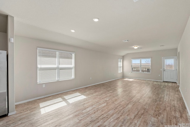 spare room with light wood finished floors, baseboards, visible vents, and recessed lighting