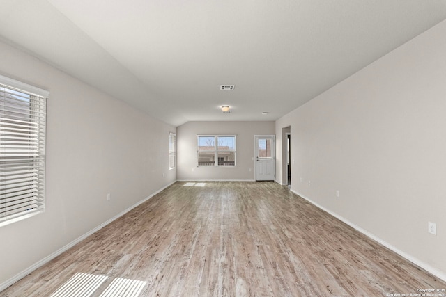 empty room featuring light wood-style floors, baseboards, and visible vents