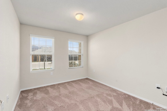 carpeted empty room with baseboards