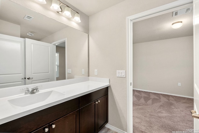 bathroom featuring baseboards, visible vents, and vanity