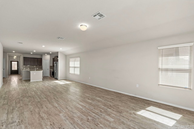 unfurnished living room featuring baseboards, recessed lighting, visible vents, and light wood-style floors