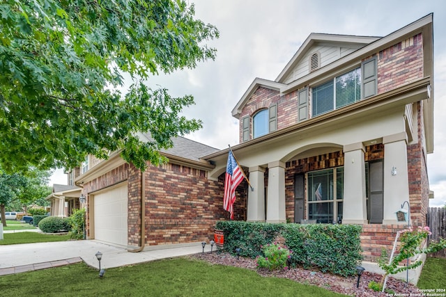 traditional-style house with covered porch, brick siding, a front lawn, and an attached garage