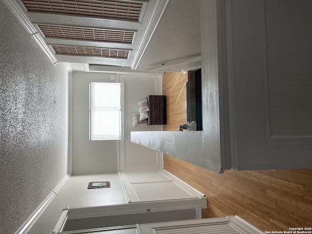 hallway with a textured wall and visible vents