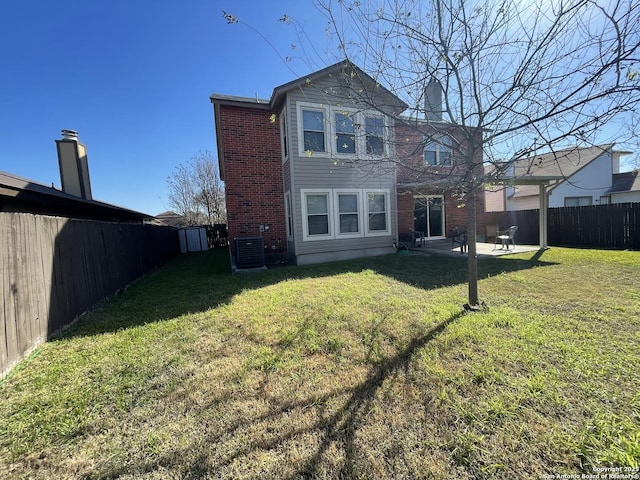 rear view of house with a patio area, a fenced backyard, a yard, and central AC unit