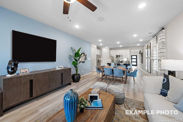 living area with baseboards, light wood finished floors, a ceiling fan, and recessed lighting