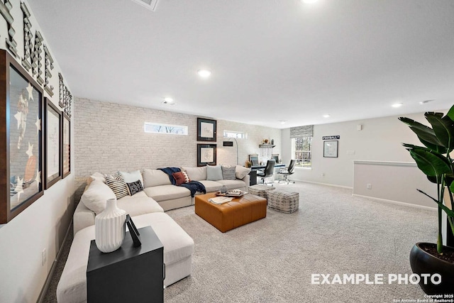 living room with carpet floors, recessed lighting, baseboards, and brick wall