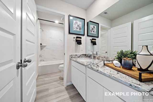 full bath with bathtub / shower combination, toilet, wood finished floors, vanity, and visible vents