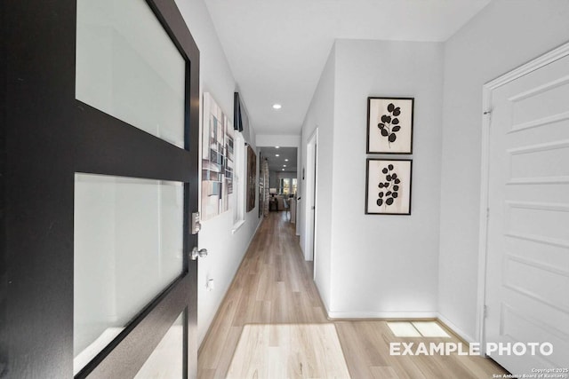 hall with light wood-style flooring, baseboards, and recessed lighting