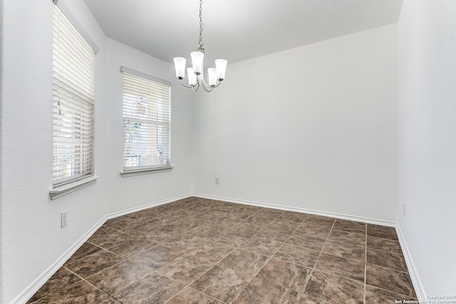 empty room featuring baseboards and an inviting chandelier