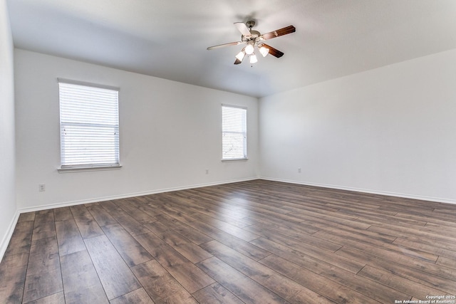 unfurnished room with baseboards, a ceiling fan, and dark wood-style flooring