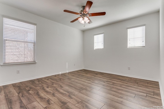 spare room featuring ceiling fan, baseboards, and wood finished floors