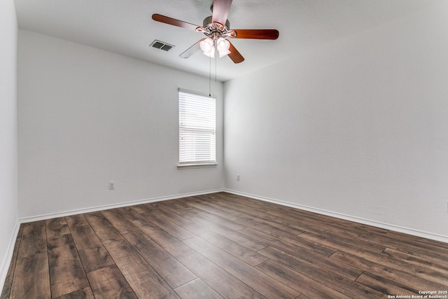 unfurnished room featuring visible vents, baseboards, dark wood finished floors, and a ceiling fan