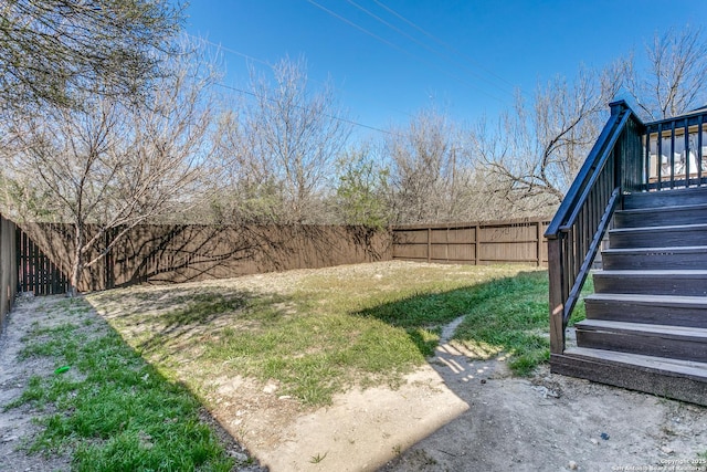 view of yard featuring a fenced backyard and stairs