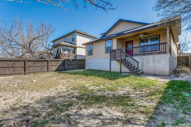 back of property featuring covered porch, a ceiling fan, and fence